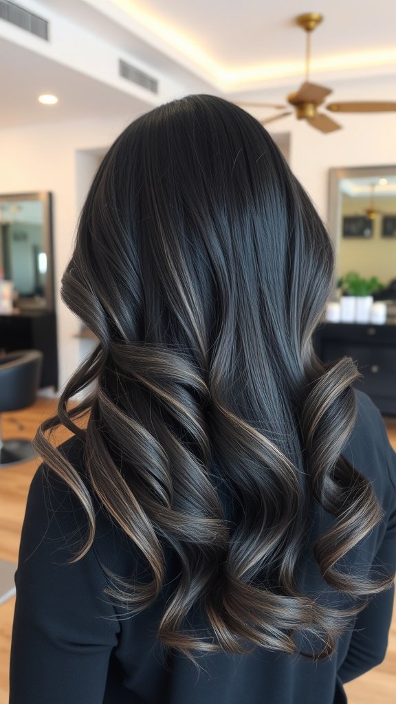 A woman with raven black hair styled in curls, featuring smoky gray tips, showcasing a chic and elegant hairstyle.