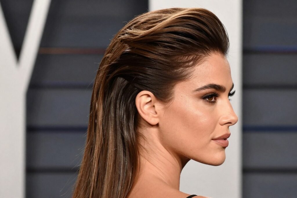 Woman with a sleek half up half down hairstyle with volume at the crown